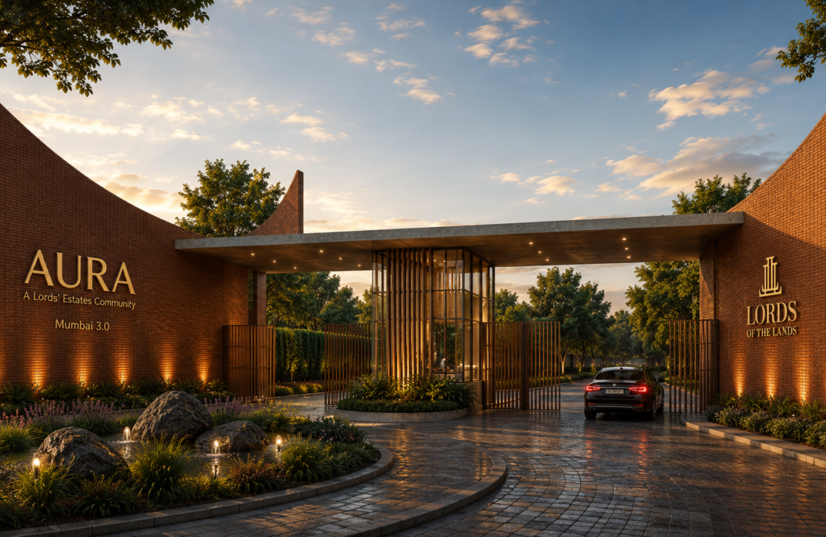 Brick entrance to Aura Lords' Estates Community with a gate, illuminated signage, and a car arriving at dusk behind landscaped gardens — Lords of the Lands