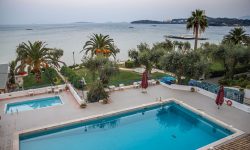 Resort pool framed by palm trees — Lords of the Lands